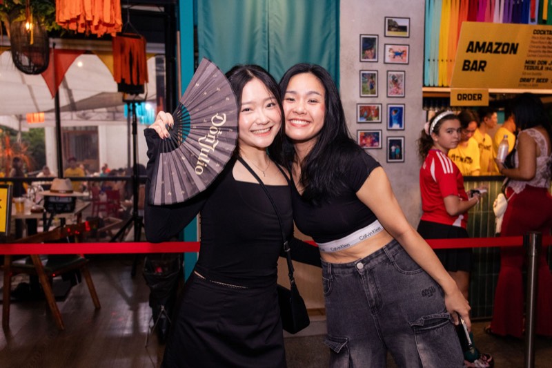 Guests posing with a branded hand fan at the Latinada Festival