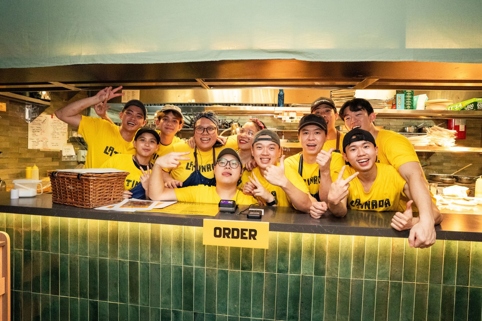 The PhotographySG event crew in matching yellow tees behind a festival food counter in Singapore