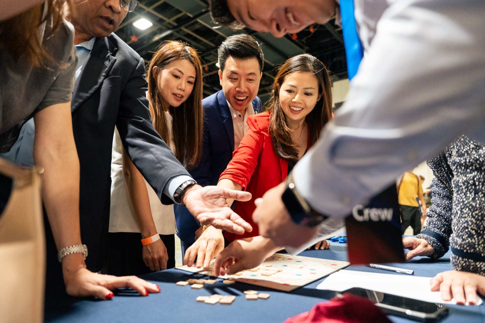 Delegates gathered around a table, smiling mid-activity at UOB's service convention in Singapore